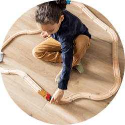 Girl playing wooden railway tarin with vinyl flooring | Jordans Flooring