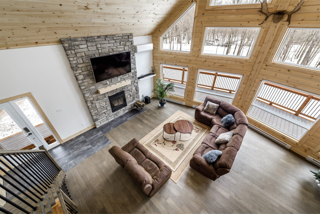 overhead view of living room with wood-look flooring and winter scene outside the window