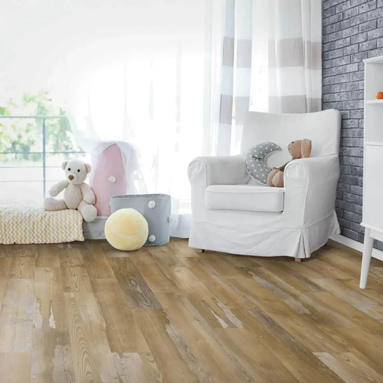 Distressed-look laminate wood flooring in a bright baby nursery featuring a white armchair and soft plush toys.