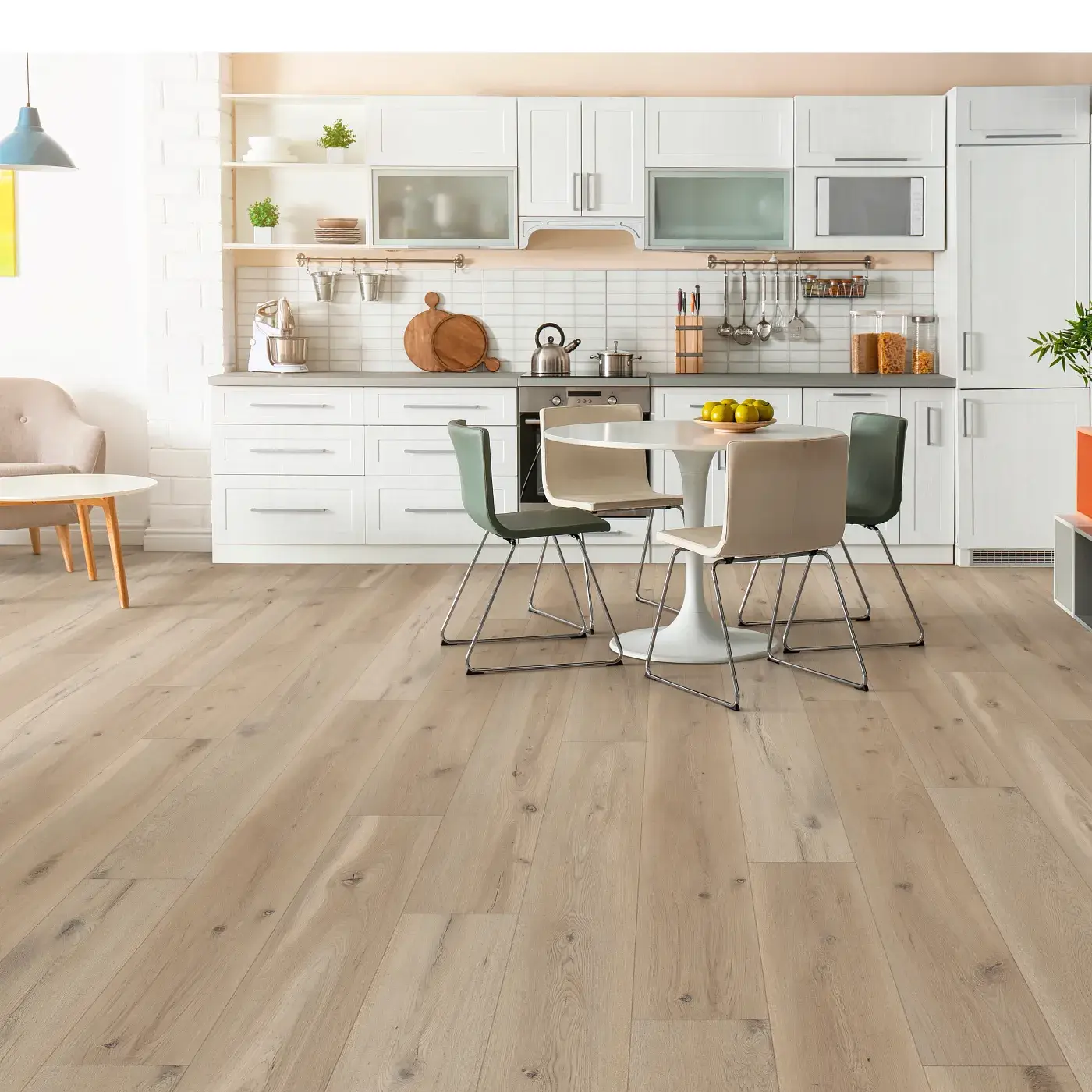 Light, natural oak-grain vinyl plank flooring in a bright, modern kitchen featuring white cabinetry and a round dining table with contemporary olive green and beige chairs.